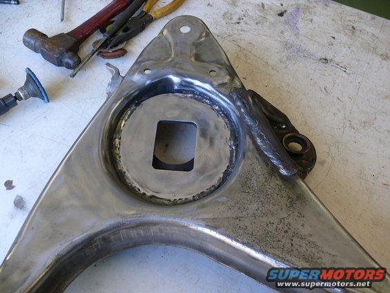 Welded suspension control arm with a square cutout in the center