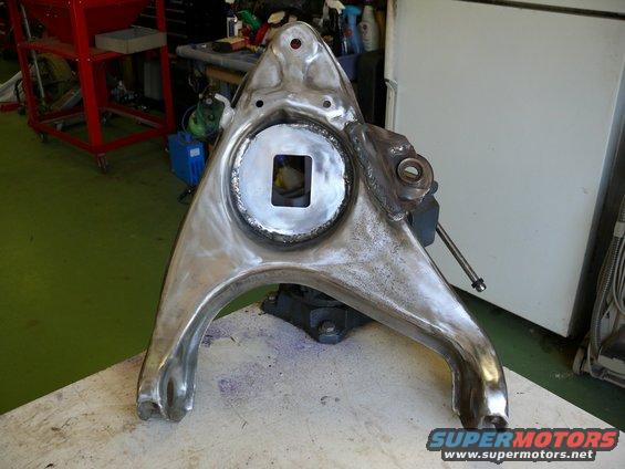 Car suspension control arm with a square opening in the center, clamped in a vise