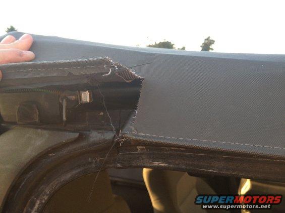 Torn seam on a 2005 Jeep Wrangler soft top, showing frayed fabric and stitching