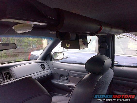 Interior shot of a car, looking forward. Overhead equipment is mounted. Another car is visible through the window