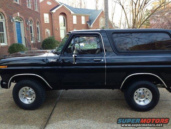 Black 1978 Ford Bronco parked on a driveway, side view