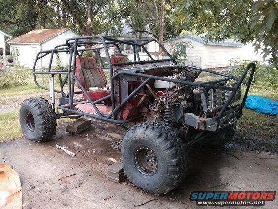Custom off-road buggy with roll cage, large tires, and exposed engine components