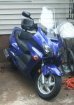 Blue scooter parked outside next to a house