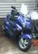 2006 Honda Reflex - A blue scooter is parked on a concrete surface next to a building.