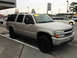 2005 Chevrolet Suburban - Silver 2005 Chevrolet Suburban SUV parked outside a dealership, with other vehicles visible.