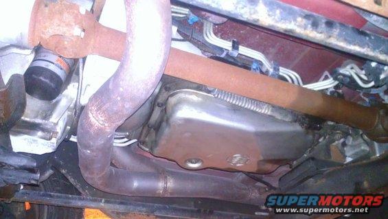 Underside view of vehicle components including exhaust pipes, transmission pan, and driveshaft