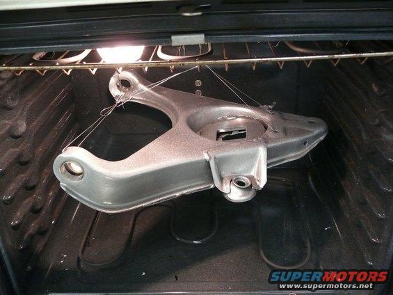 Control arm suspended by wires inside an oven