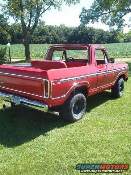 Red 1978 Ford Bronco parked on grass, rear quarter view