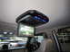 2008 Ford F-450 - The interior of a vehicle features an overhead entertainment system with a drop-down screen, showing a scene of a house.