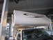 2008 Ford F-450 - A truck camper unit is mounted on a pickup truck, parked next to another vehicle.