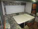 2008 Ford F-450 - Interior view of a camper dinette area, showing seating, a table, and a window.