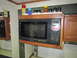 2008 Ford F-450 - A Sharp Carousel microwave oven is installed in a recreational vehicle, with various kitchen items on the shelf above.