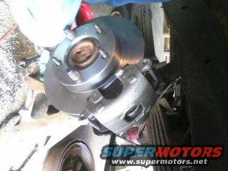 Ford Bronco brake caliper and rotor assembly being worked on. SuperMotors.net logo visible
