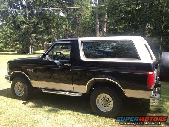 1992 Ford Bronco parked on grass with trees in background