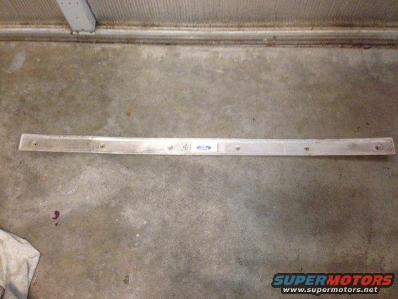 Metal trim piece with Ford logo and some numbers