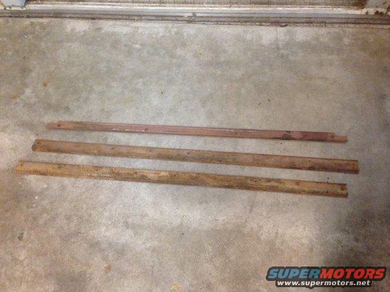 Three metal trim pieces lying on a concrete floor