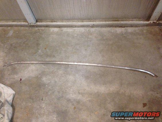 long, curved chrome trim piece on concrete floor