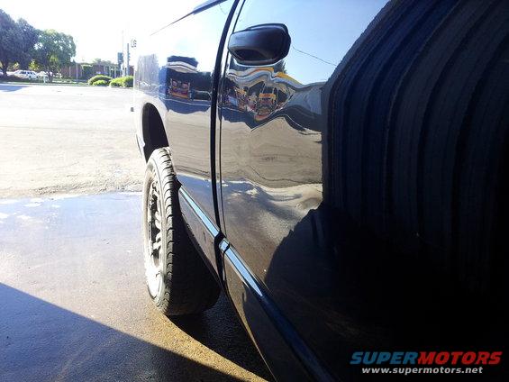 Side view of a black 2007 Dodge 1500 pickup truck, showing the rear wheel and door