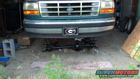 1996 Ford F-150 front end, grille, and bumper with front axle removed and resting on the ground