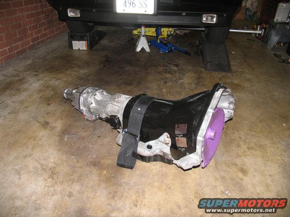 Transmission with purple torque converter and black strap on concrete floor