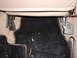 1993 Mazda MX-3 - Close-up of car interior seat mounting points and floor carpet.
