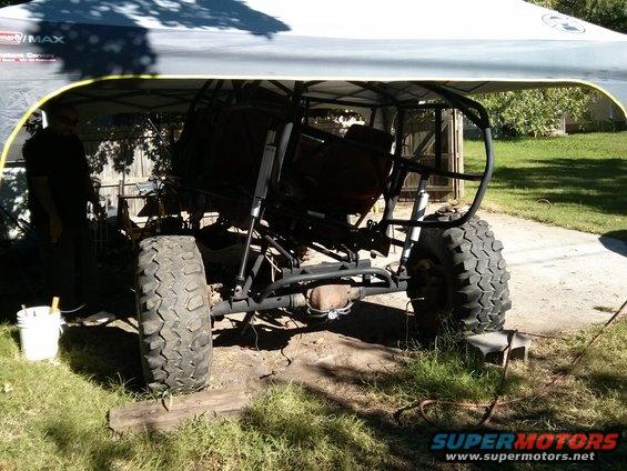 Off-road buggy frame with large tires, under a canopy
