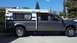 2000 Ford F-250 - A gray pickup truck is equipped with a camper shell, seen from the side. The truck appears to be a 2008 model.