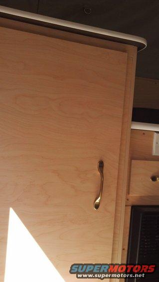 Interior camper cabinet with wooden door and brass handle