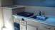 2000 Ford F-250 - Interior view of a camper's kitchenette area, a sink, faucet, and a portable stovetop.
