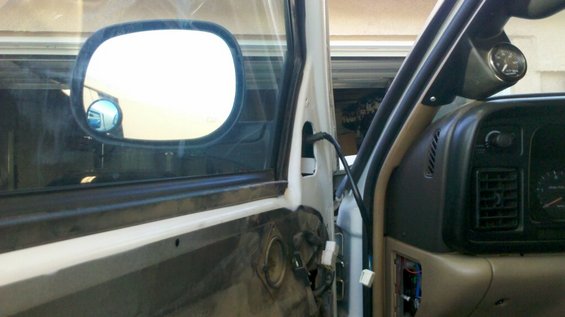 Interior view of a truck door panel removed, showing wiring and a gauge on the dashboard