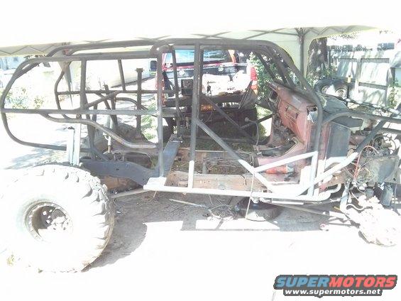 Custom off-road buggy build with a roll cage and large tires, appears to be a project in progress