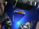 2006 Honda Reflex - Close-up of the front of a blue scooter, showing the headlights and HONDA emblem.