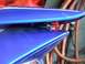 2006 Honda Reflex - Close-up of a blue scooter's tail light assembly, white pinstripes and a visible red light component.