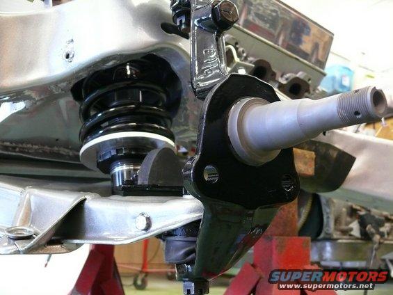 Close-up of a car's front suspension assembly, showing a shock absorber and steering knuckle