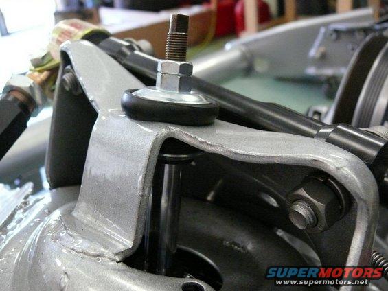 close-up of a car's suspension part with a bolt and rubber bushing