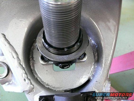 Close-up of a QAI branded suspension part with threaded shaft