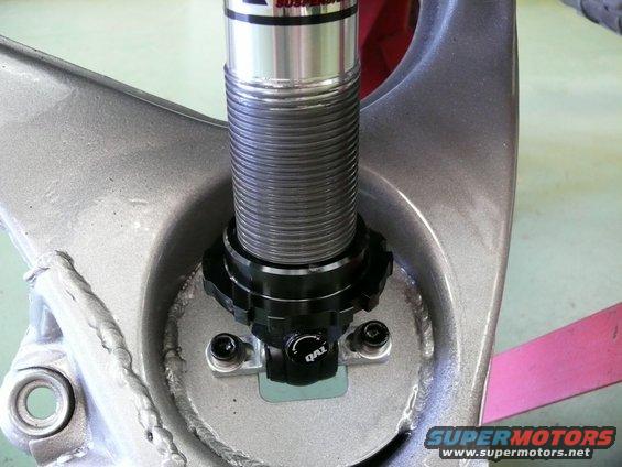 Close-up of a coilover shock absorber with a QAL adjustment knob