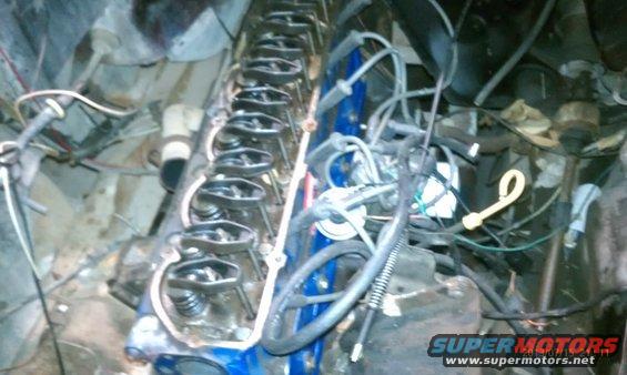 Engine bay with valve covers removed, showing internal components and wiring