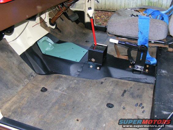 Vehicle interior floor with rubber matting, shifter assembly, and seatbelt