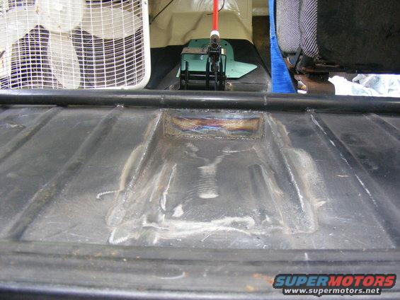 Black metal panel with visible welds and a rectangular cutout, interior view
