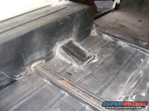 Interior floor pan with welded repairs and a metal grate