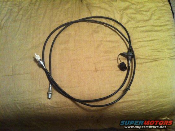 Speedometer cable with two connectors and a black plug