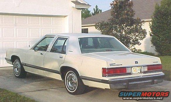 Cream 1989 Mercury Grand Marquis rear view. Visible text: SUPERMOTORS