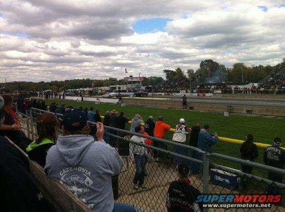 Spectators watch a drag race from bleachers