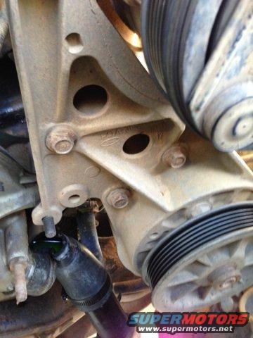 Close-up of engine bracket with Ford logo, pulleys, and hoses