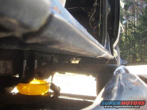 Underbody view with oil drain pan; door wiring visible