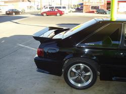 1993 Ford Mustang GT rear quarter panel and spoiler, black paint, aftermarket wheels