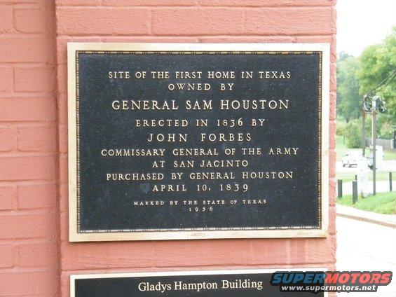 Bronze plaque on brick wall detailing historical site information