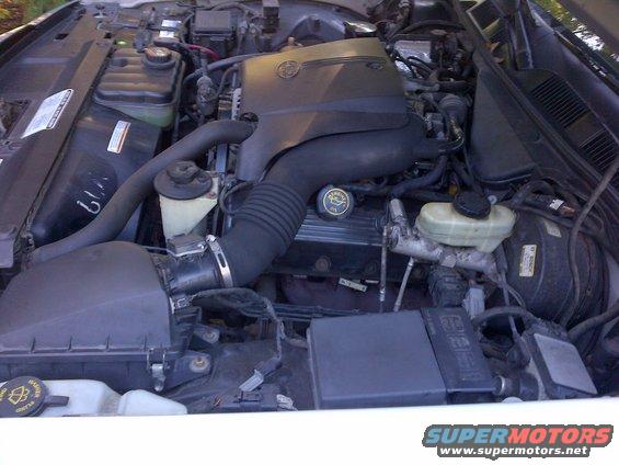 Engine bay with black air intake, brake fluid reservoir, and engine cover