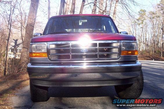 Red 1995 Ford Bronco front view with chrome grille and bumper